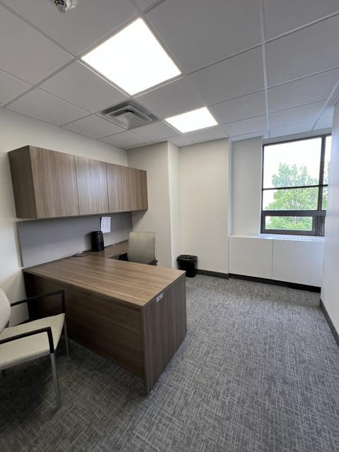 Attorney office with desk, built in cabinets, chairs and window