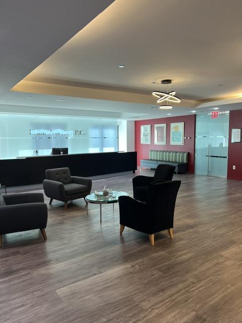 Large room with receptiondesk, chairs and table